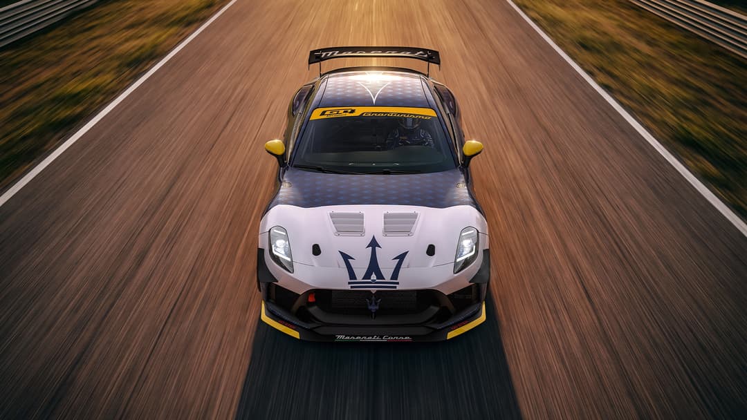 Maserati Project GT4 blanche et noire avec détails jaunes, vue de dessus en action sur circuit