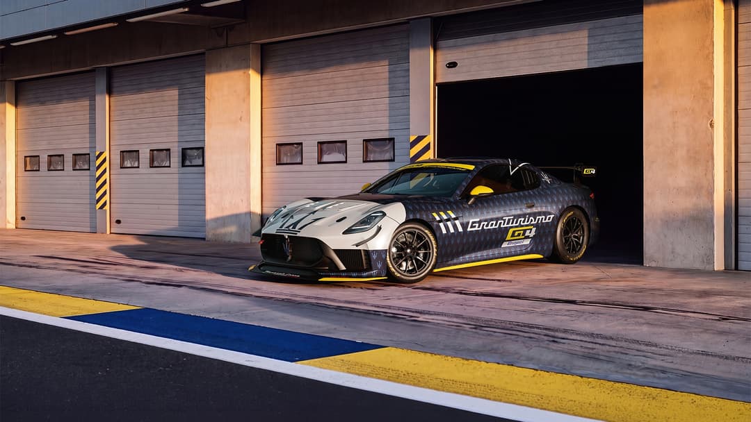 Maserati Project GT4 de couleur bleu et jaune avec bande blanche à l'avant, garée devant un hangar avec portes sectionnelles