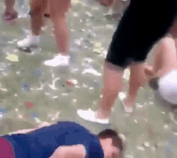Festivaliers dansant sur une piste au sol parsemée de confettis colorés