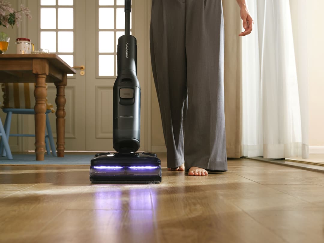 Roborock F25 Steam nettoyant un parquet, sa barre lumineuse bleue indiquant une zone propre dans un intérieur lumineux