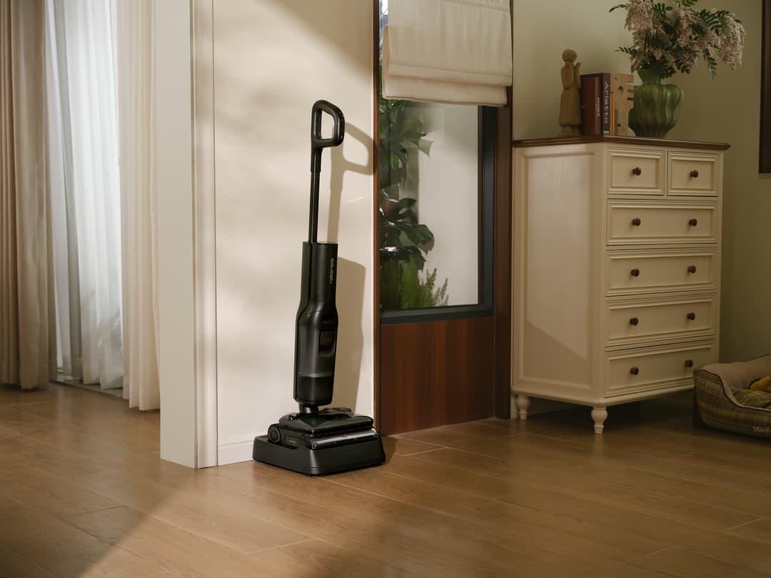 Roborock F25 Steam, nettoyeur à vapeur noir posé sur un parquet en bois massif dans un salon