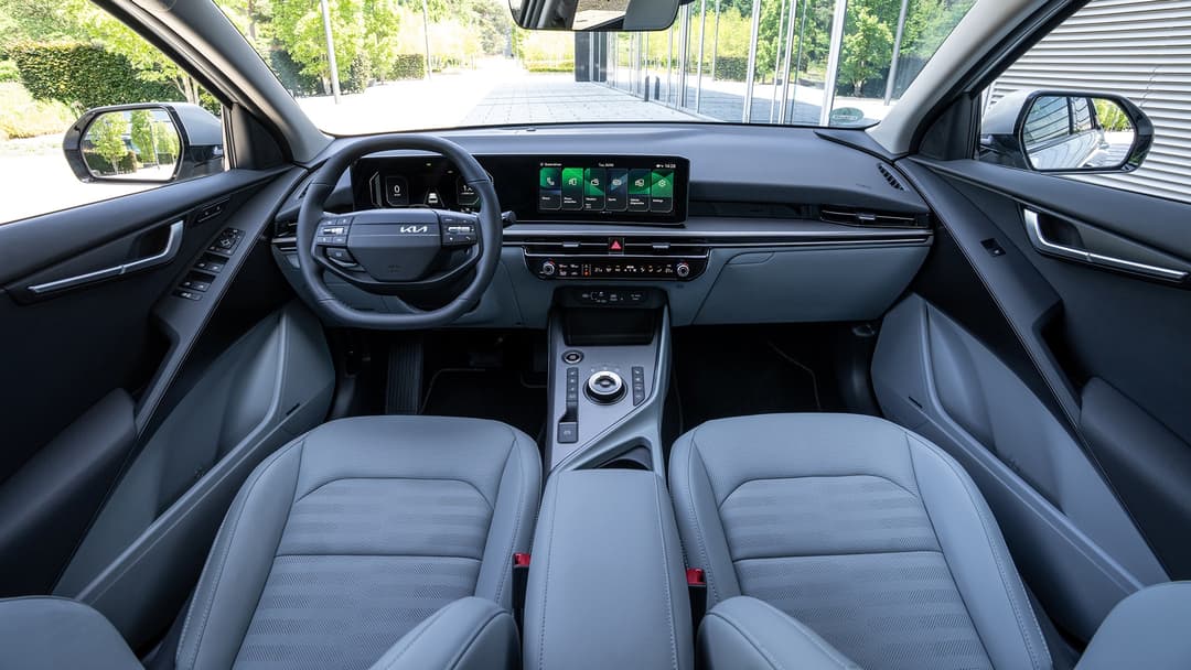Habitacle du Kia Niro avec tableau de bord moderne, écran tactile, volant et sièges gris clair spacieux