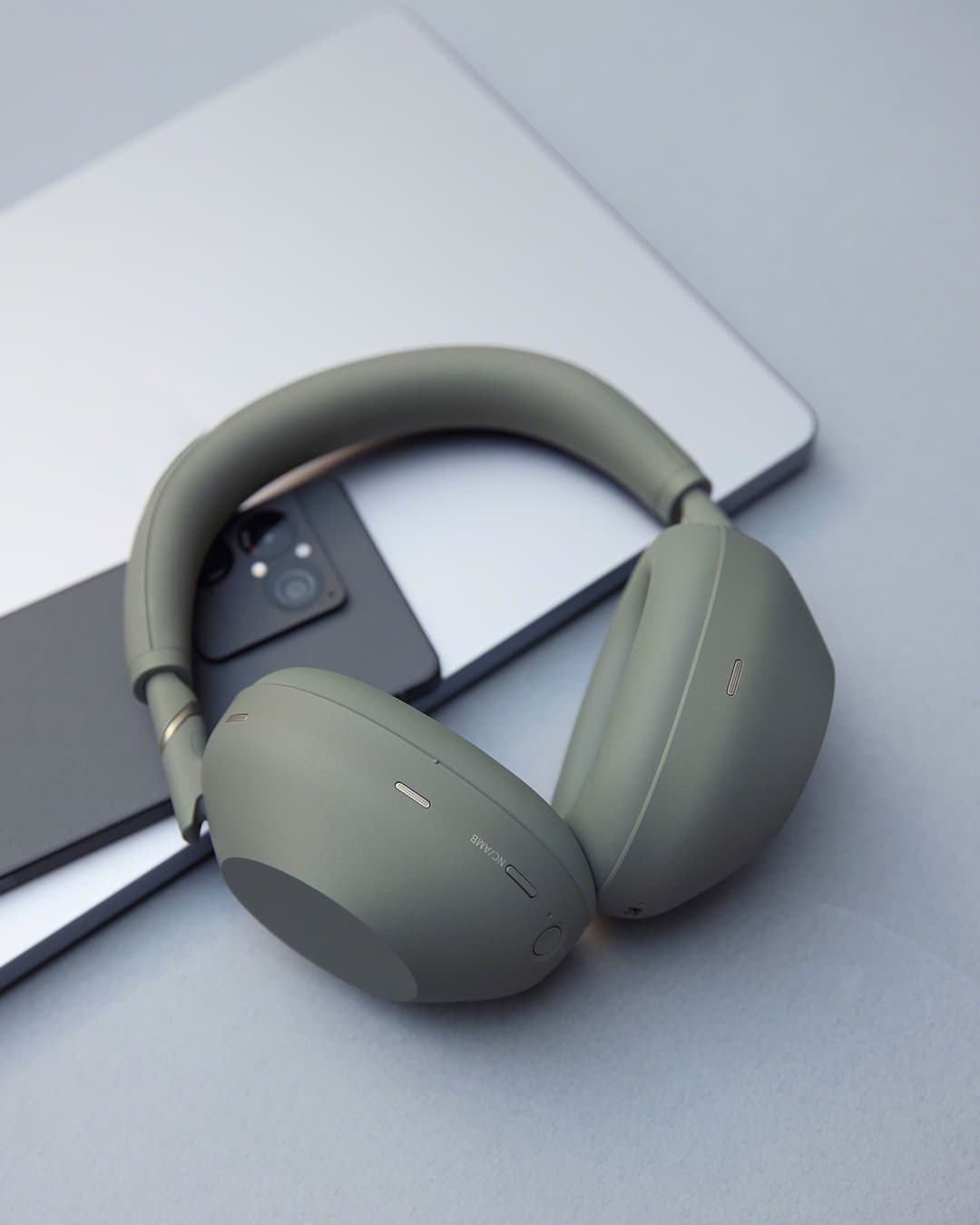 Casque Sony WH-1000XM6 couleur olive posé sur un laptop gris, vue de trois quarts