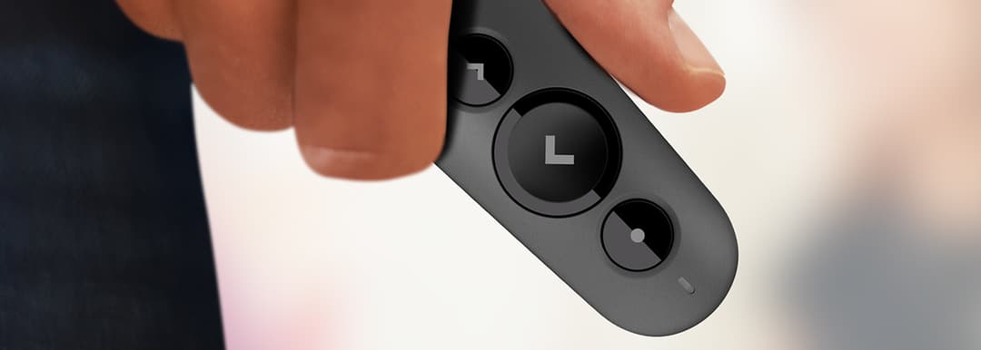 Télécommande de présentation Logitech R500 grise tenue en main, avec boutons de navigation et logo Logitech