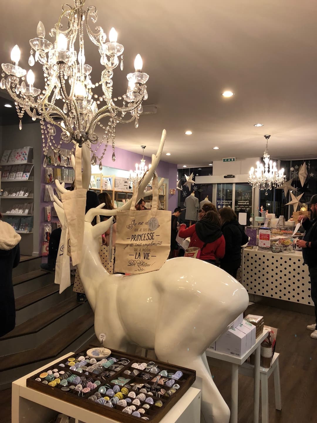 Intérieur de la pâtisserie Princesse Cupcakes avec cerfs blancs décorés, lustre en cristal et comptoir de cupcakes colorés