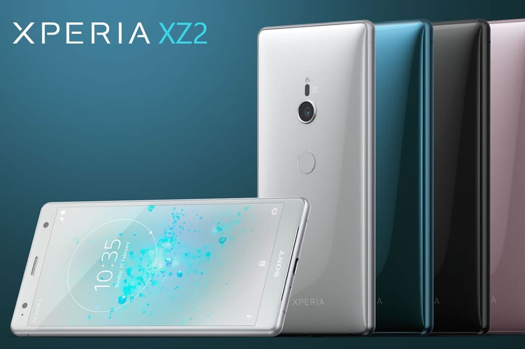 Sony Xperia XZ2 blanc avec écran affiché en avant-plan, suivi de trois modèles supplémentaires en bleu, noir et rose sur fond bleu