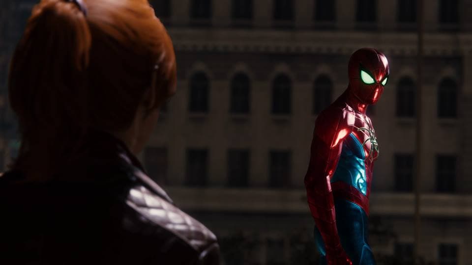 Spider-Man en costume rouge et bleu face à un personnage dans l'ombre, devant un immeuble urbain