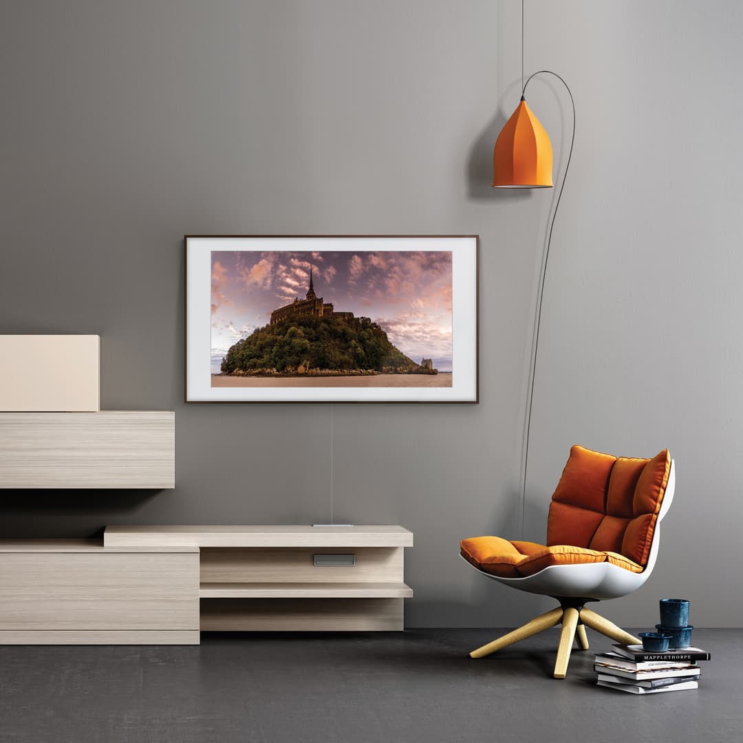 Samsung The Frame 2.0 affichant un château sur une île, encadré au mur comme un tableau dans un salon moderne