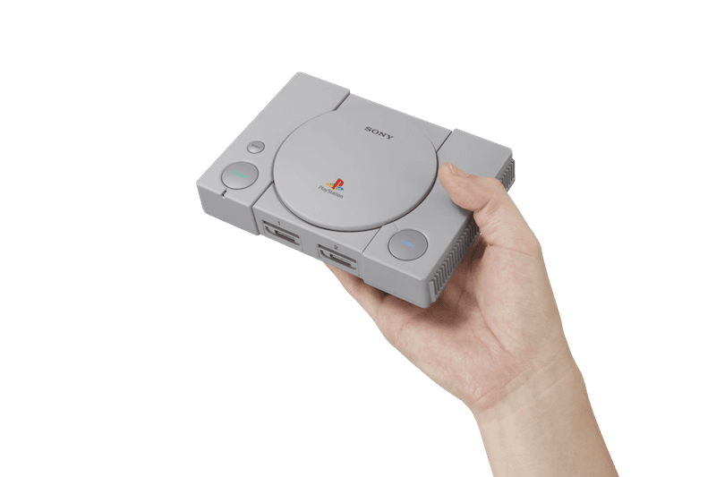 PlayStation Classic grise miniature tenue dans une main, réplique de la console originale avec le logo PlayStation