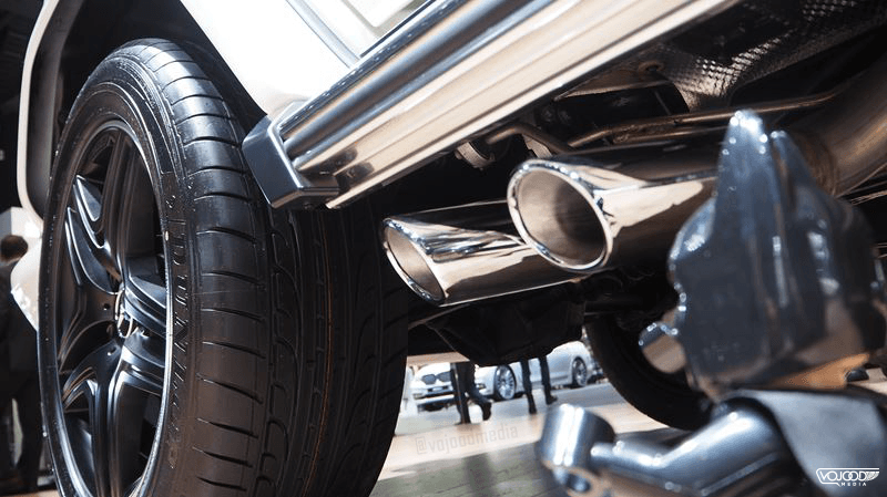 Détail du bas de caisse d'un Mercedes-AMG G 63 Brabus noir, montrant les pneus massifs et les sorties d'échappement chromées