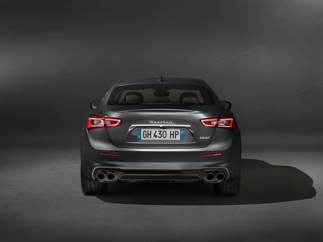Maserati Ghibli GranLusso grise vue de l'arrière, phares rouges allumés, fond neutre