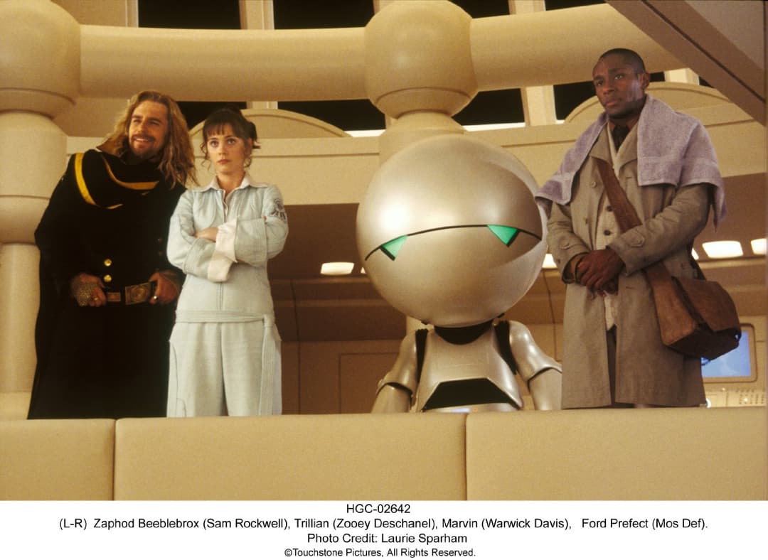 Arthur Dent aux côtés de Ford Prefect et d'autres passagers dans le vaisseau spatial de H2G2, intérieur futuriste beige et doré