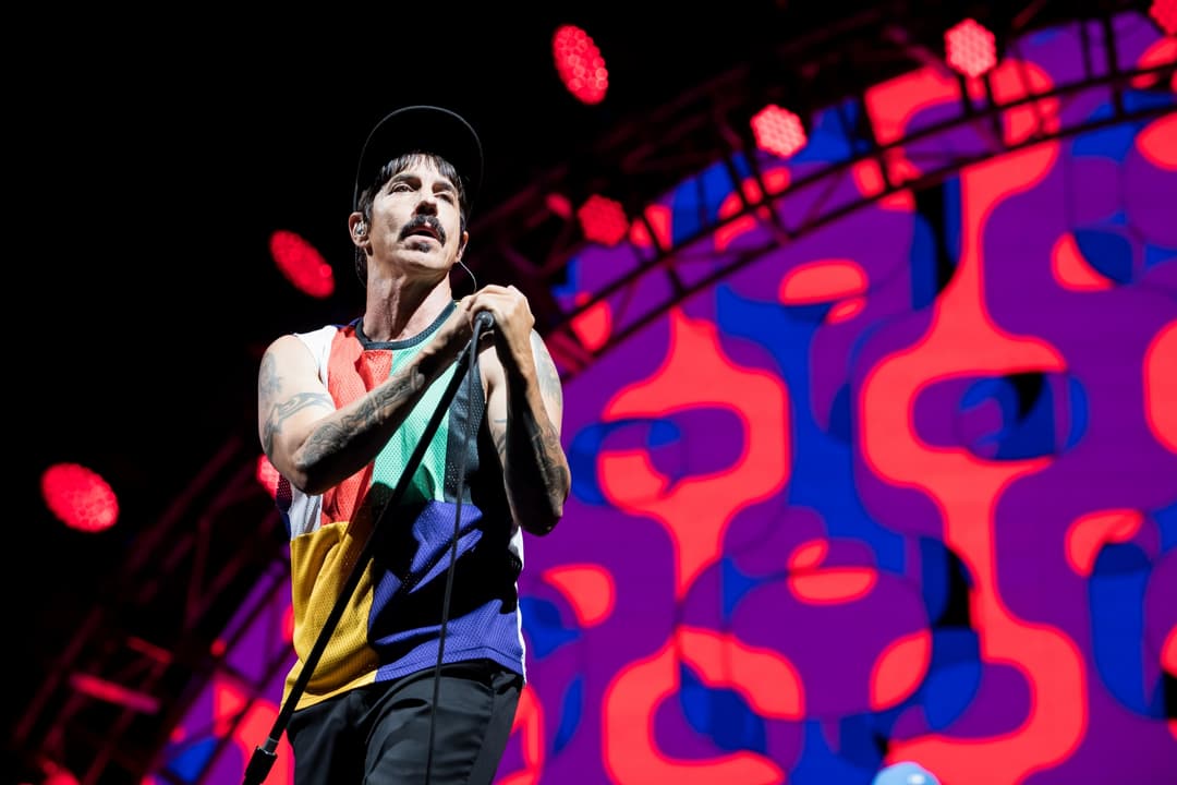 Anthony Kiedis des Red Hot Chili Peppers chantant au micro lors du Paléo Festival 2017, éclairage rouge et violet