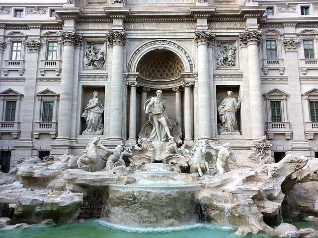 Fontaine de Trevi à Rome, façade blanche avec colonnes, statues et eau turquoise en premier plan