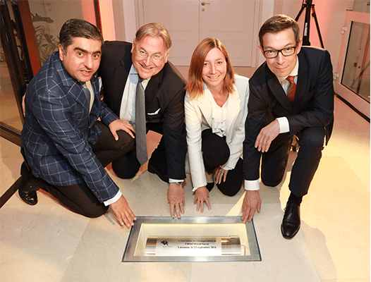 Quatre responsables de l'Hôtel Royal Savoy Lausanne posent autour d'une plaque commémorative lors de l'inauguration de l'établissement rénové